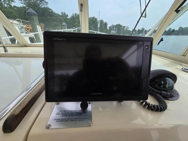 Slide: The Image of Garmin GPS on 2001 Mainship Pilot 30 Sedan boat dashboard with compass and certification plaque. - 16