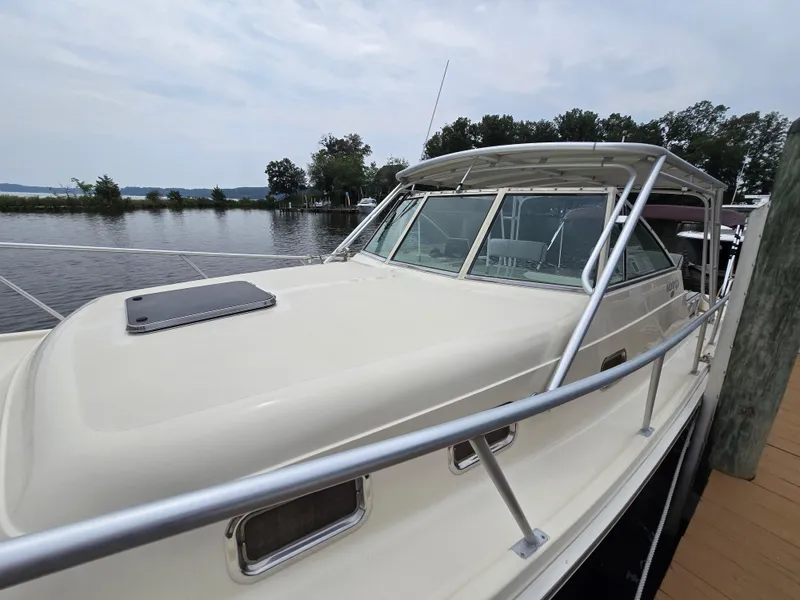 Slide: The Image of 2001 Mainship Pilot 30 Sedan docked by a serene waterfront. - 2