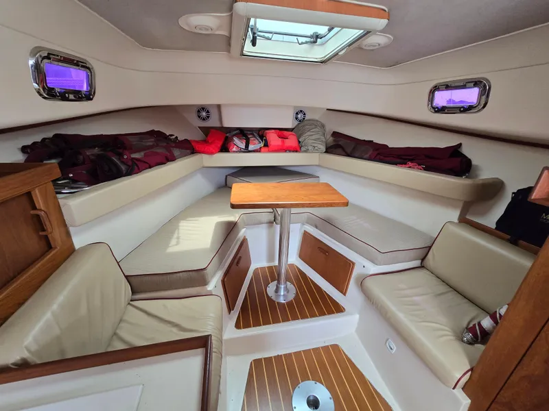 Slide: The Image of 2001 Mainship Pilot 30 Sedan interior with seating, table, and storage. - 20