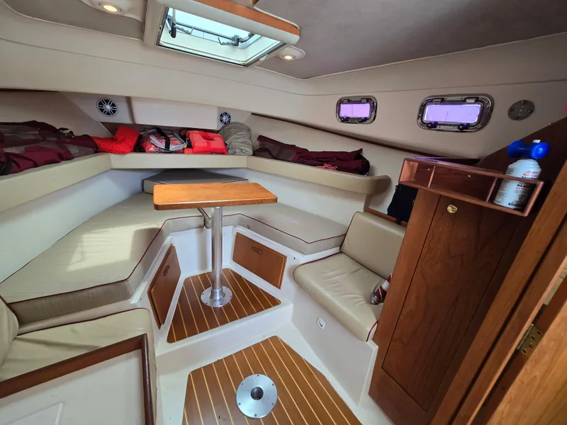 Slide: The Image of 2001 Mainship Pilot 30 Sedan cabin interior with seating, table, and storage. - 22