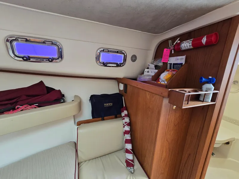 Slide: The Image of Interior of a 2001 Mainship Pilot 30 Sedan with wooden cabinetry and nautical equipment. - 23