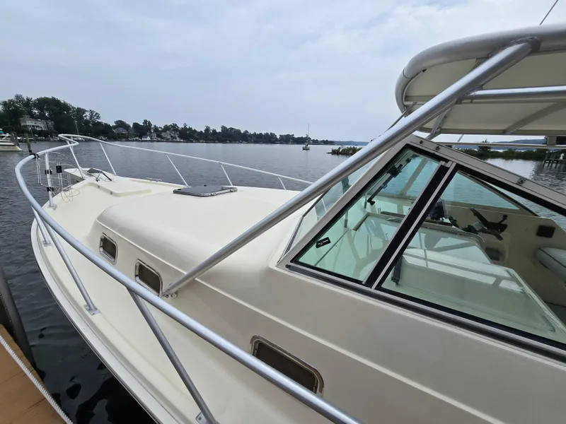 Slide: The Image of 2001 Mainship Pilot 30 Sedan docked by a serene waterfront. - 3