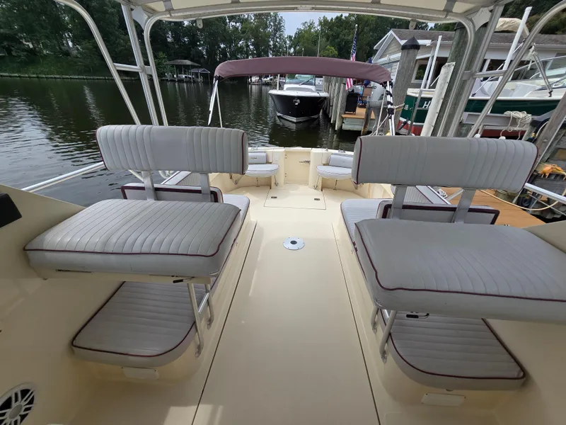 Slide: The Image of 2001 Mainship Pilot 30 Sedan interior with cushioned seating, docked by the water. - 30