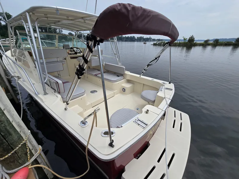 Slide: The Image of 2001 Mainship Pilot 30 Sedan docked by calm waters, featuring spacious seating and canopy. - 34