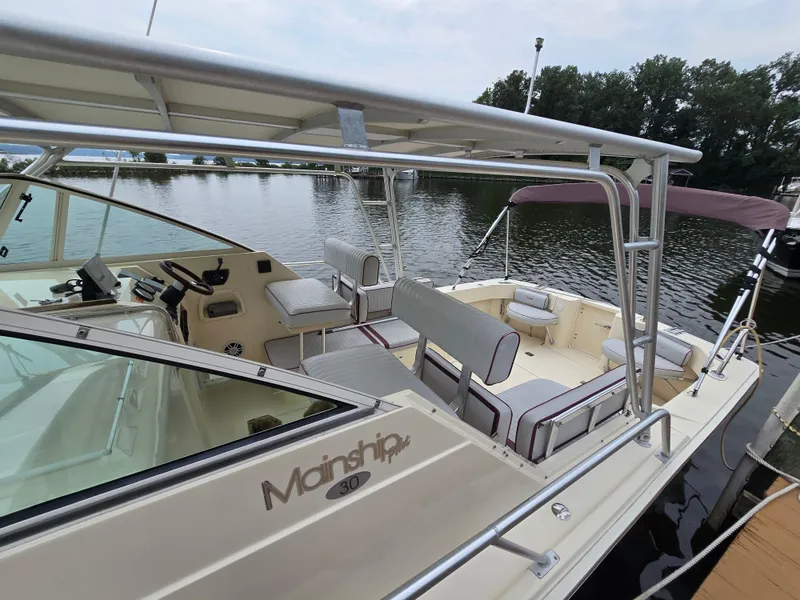 Slide: The Image of 2001 Mainship Pilot 30 Sedan boat docked, featuring spacious seating and helm area. - 4