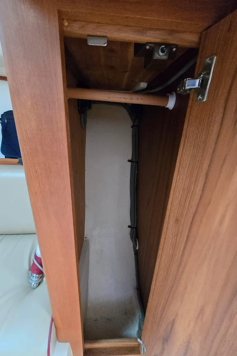 Slide: The Image of 2001 Mainship Pilot 30 Sedan interior cabinet with wooden finish and visible piping. - 43