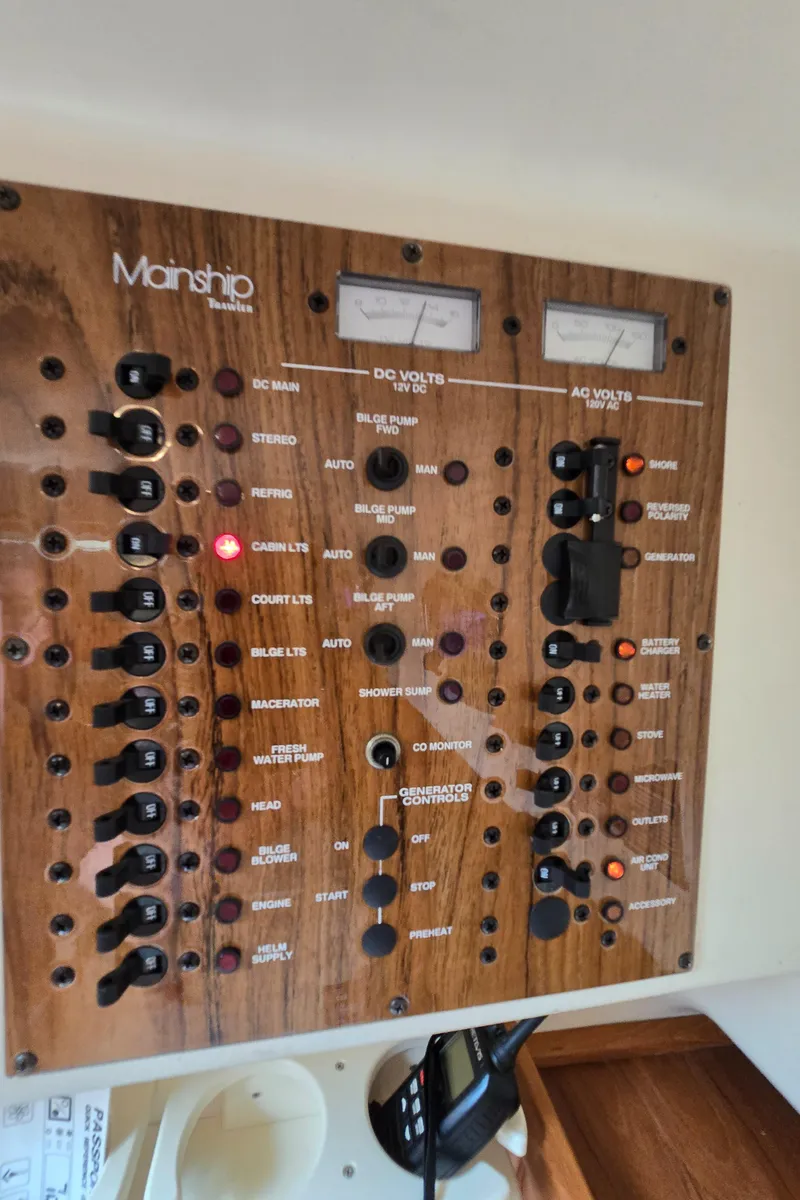 Slide: The Image of Control panel of a 2001 Mainship Pilot 30 Sedan boat with various switches and gauges. - 46