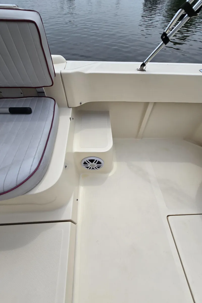Slide: The Image of 2001 Mainship Pilot 30 Sedan interior with cushioned seating and speaker, overlooking water. - 47