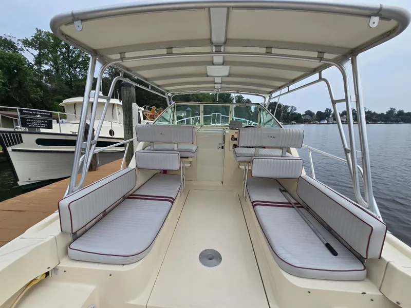 Slide: The Image of 2001 Mainship Pilot 30 Sedan boat interior with seating, docked by the water. - 7