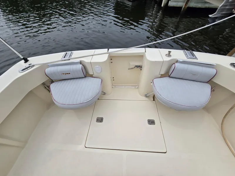 Slide: The Image of 2001 Mainship Pilot 30 Sedan boat interior with cushioned seating and water view. - 9