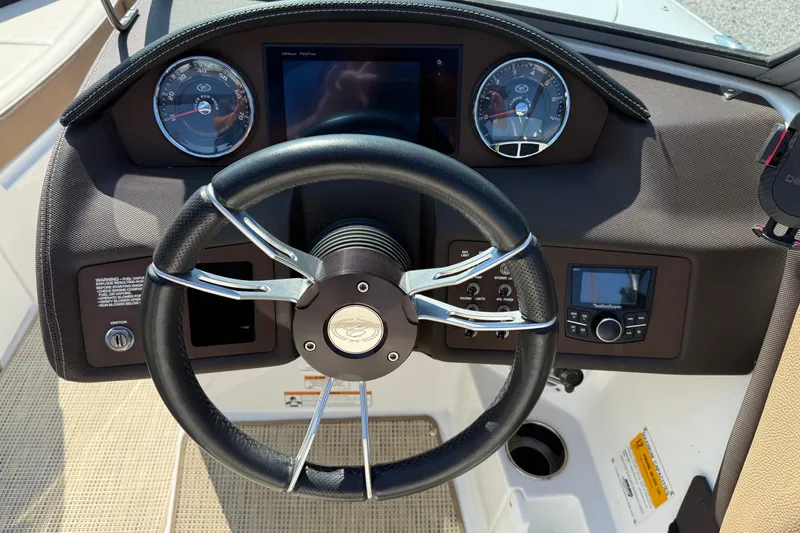 Slide: The Image of Steering wheel and dashboard of a 2017 Cobalt 220S boat, featuring modern controls. - 12