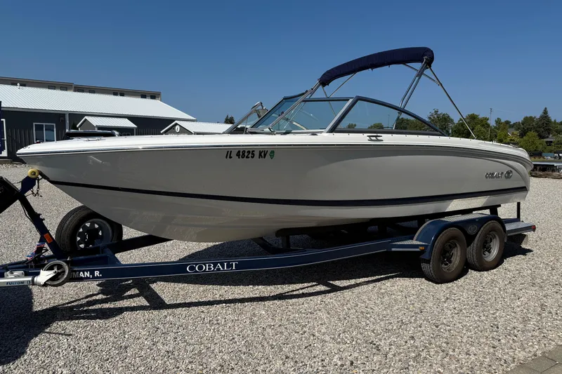 Slide: The Image of 2017 Cobalt 220S boat on trailer, parked on gravel, with blue canopy. - 7