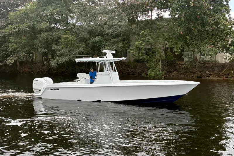 Slide: The Image of 2026 Contender 32 ST boat cruising on a calm river, surrounded by lush greenery. - 12