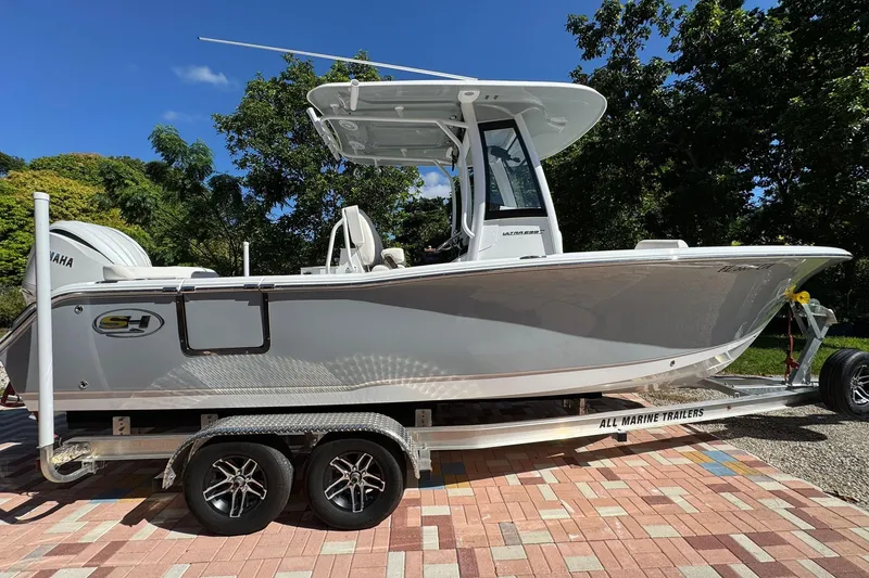 The Image of 2025 Sea Hunt Ultra 239 SE boat on trailer, parked outdoors, with Yamaha engine. - 0