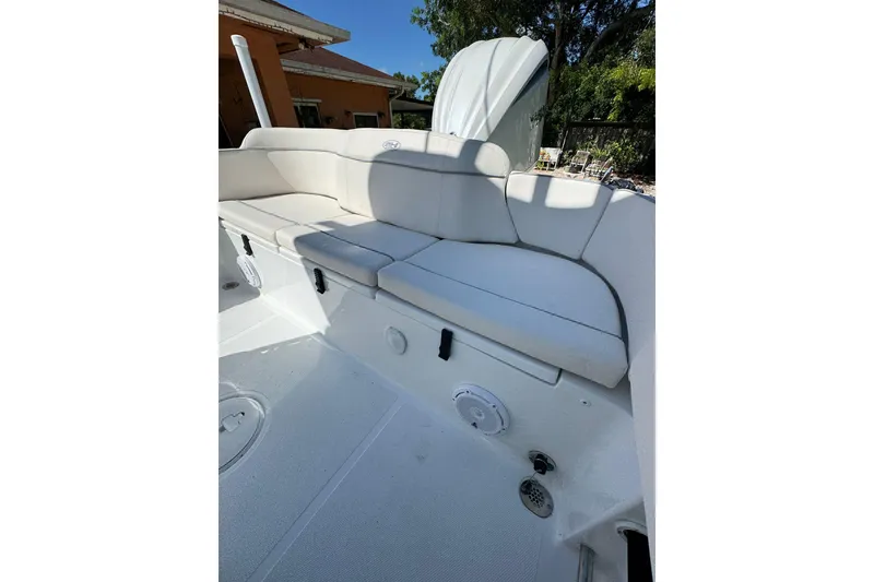 Slide: The Image of 2025 Sea Hunt Ultra 239 SE boat interior with white cushioned seating. - 10
