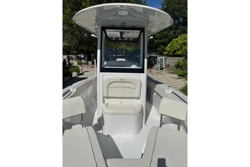 Slide: The Image of 2025 Sea Hunt Ultra 239 SE boat interior with seating and console, outdoors. - 18