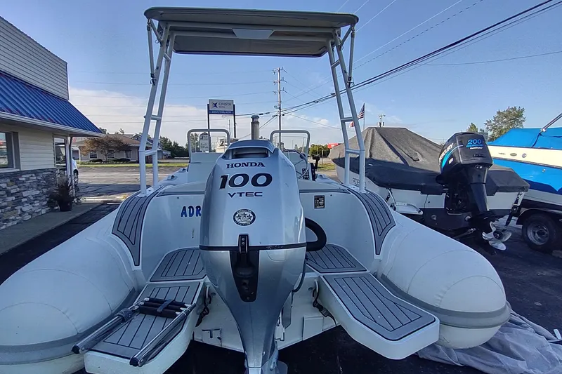 Slide: The Image of 2024 Valken 520 boat with Honda 100 VTEC engine, parked outdoors. - 2