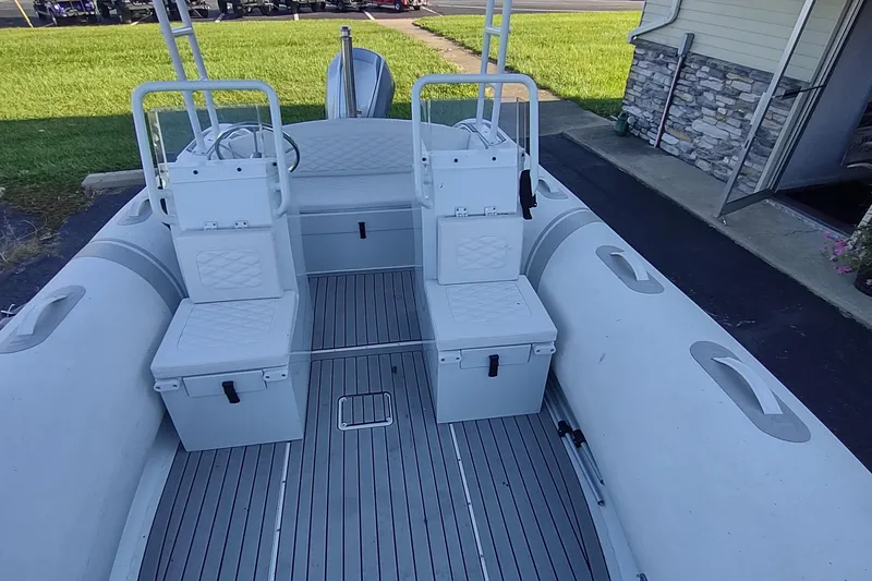 Slide: The Image of 2024 Valken 520 boat interior with dual seating and steering console, parked on pavement. - 3