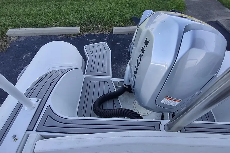 Slide: The Image of 2024 Valken 520 boat with Honda outboard motor, parked on pavement near grass. - 9