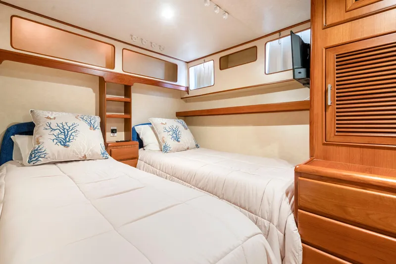 Slide: The Image of Twin cabin with coral-themed pillows in a 1995 Fleming 55 yacht. - 11