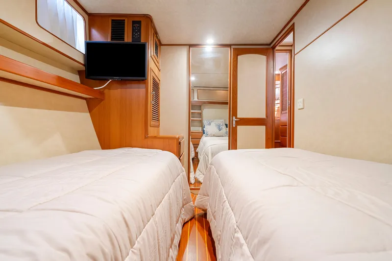 Slide: The Image of Interior of 1995 Fleming 55 yacht cabin with twin beds and TV. - 12