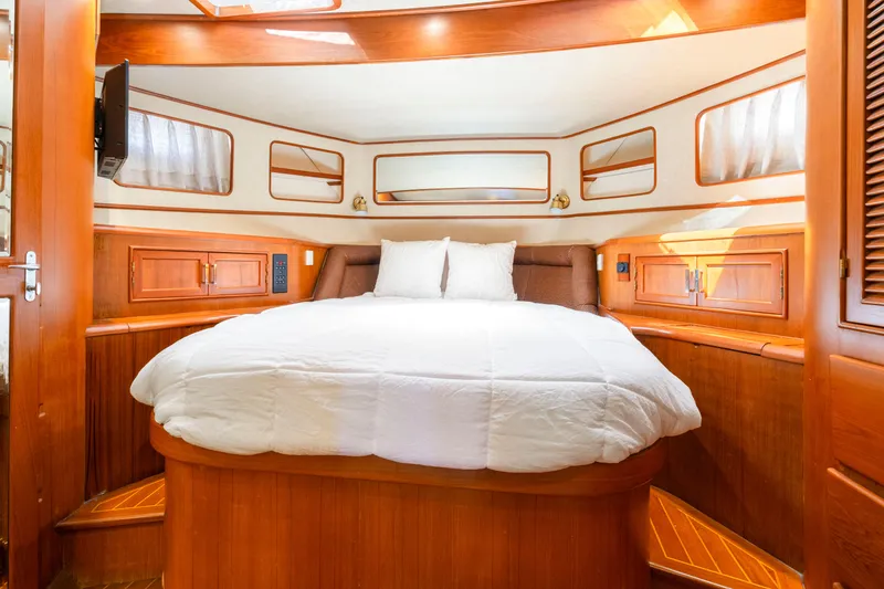 Slide: The Image of Luxurious cabin interior of a 1995 Fleming 55 yacht with cozy bed and wooden accents. - 16