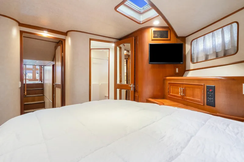 Slide: The Image of Luxurious 1995 Fleming 55 yacht bedroom with wood accents and modern amenities. - 17