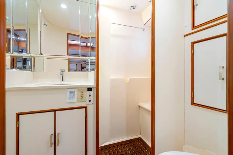 Slide: The Image of Bathroom interior of 1995 Fleming 55 yacht with mirrored cabinets and wooden accents. - 18