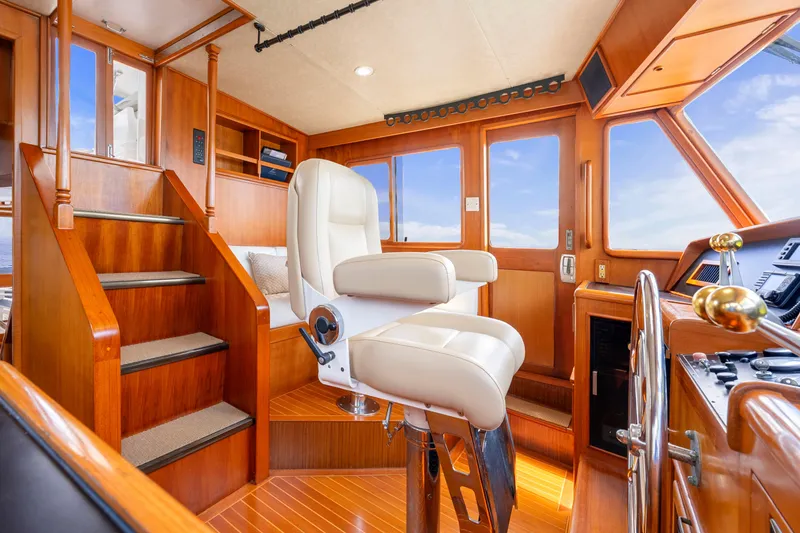 Slide: The Image of Luxurious 1995 Fleming 55 yacht interior with captain's chair and wooden helm station. - 21