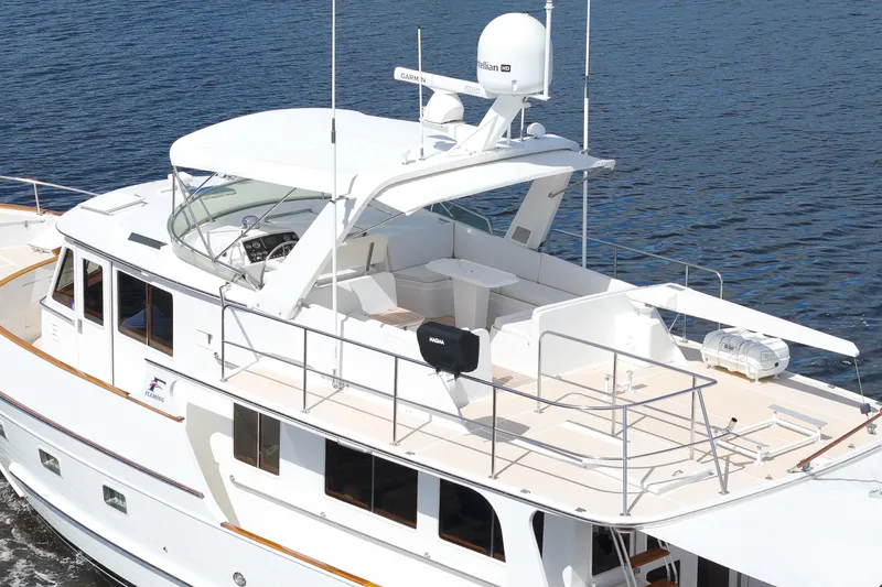 Slide: The Image of 1995 Fleming 55 yacht on water, featuring spacious deck and modern navigation equipment. - 25