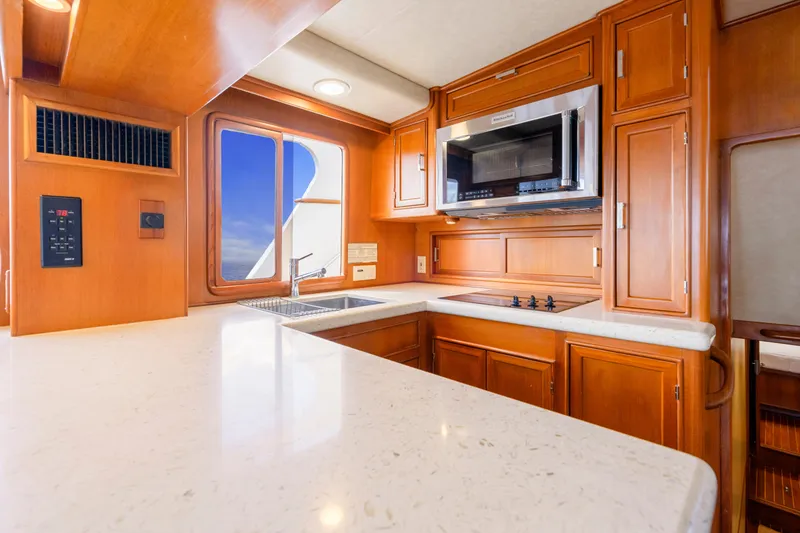 Slide: The Image of Luxurious kitchen interior of 1995 Fleming 55 yacht with modern appliances and wooden cabinetry. - 6