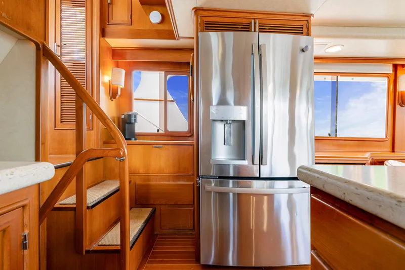 Slide: The Image of Luxurious 1995 Fleming 55 yacht interior with stainless steel refrigerator and wooden cabinetry. - 8