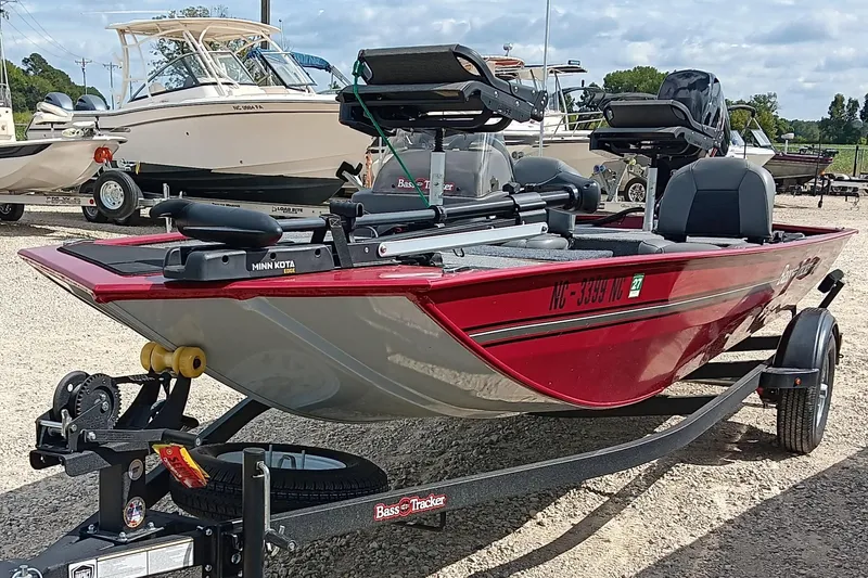 Slide: The Image of 2024 Tracker Bass Tracker Classic XL boat on trailer, red color, parked outdoors. - 5