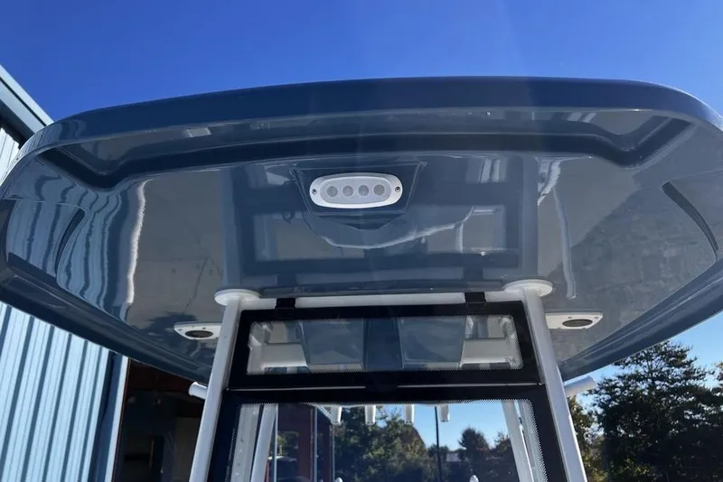 Slide: The Image of 2026 Tidewater 2300 Carolina Bay boat T-top with integrated lighting, under clear blue sky. - 31