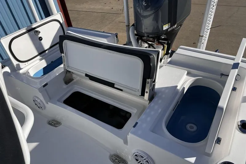 Slide: The Image of 2026 Tidewater 2300 Carolina Bay boat with open storage compartments and motor. - 39