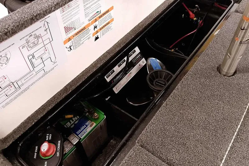 Slide: The Image of 2025 Ranger Z518 Ranger Cup Equipped boat battery compartment with wiring and safety labels. - 36