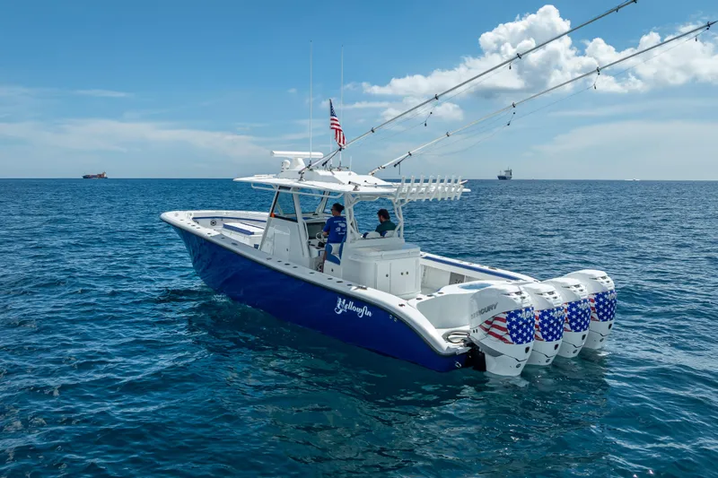 Slide: The Image of 2023 Yellowfin 39 Offshore boat with four engines on open sea under blue sky. - 11