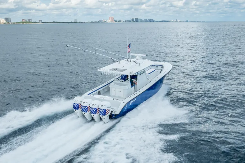 Slide: The Image of 2023 Yellowfin 39 Offshore boat cruising on open water with city skyline in background. - 22