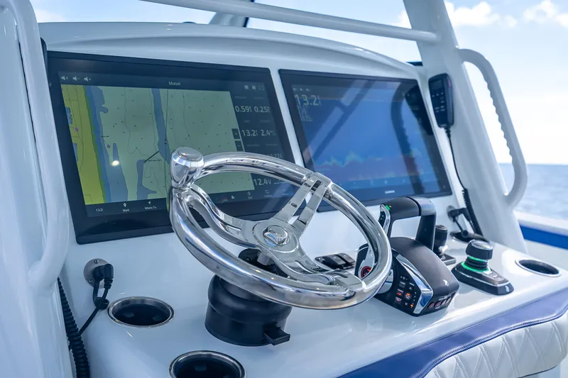 Slide: The Image of Control panel of 2023 Yellowfin 39 Offshore boat with navigation screens and steering wheel. - 40