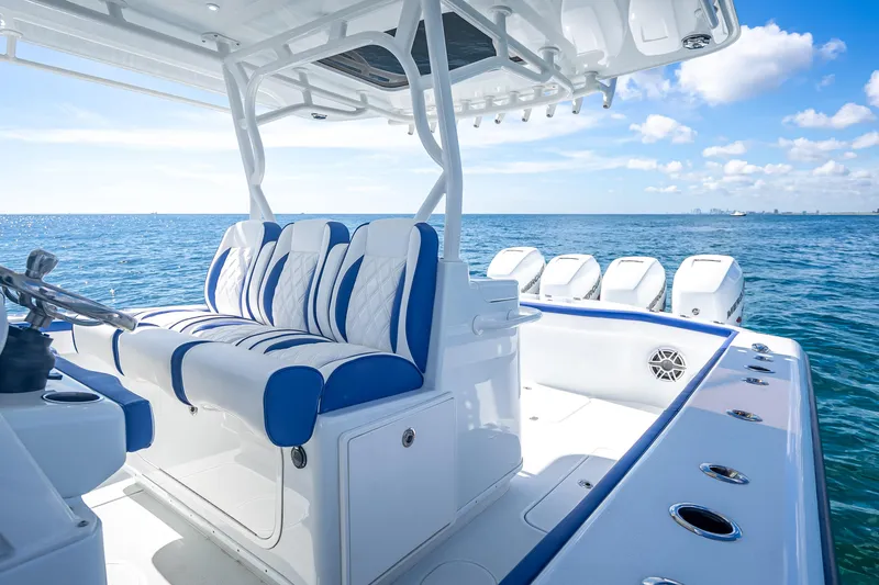 Slide: The Image of 2023 Yellowfin 39 Offshore boat interior with blue and white seating, ocean view. - 45
