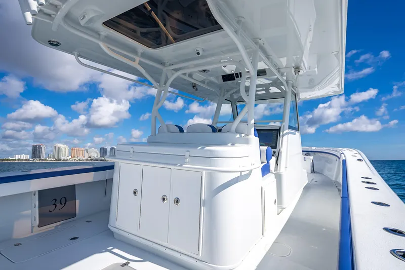 Slide: The Image of 2023 Yellowfin 39 Offshore boat on open water, clear sky, city skyline in background. - 52