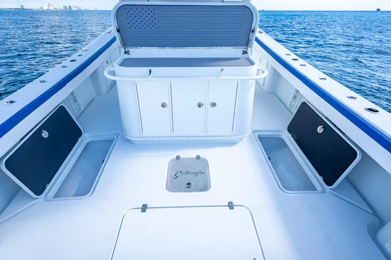 Slide: The Image of 2023 Yellowfin 39 Offshore boat deck with storage compartments, open sea view. - 53