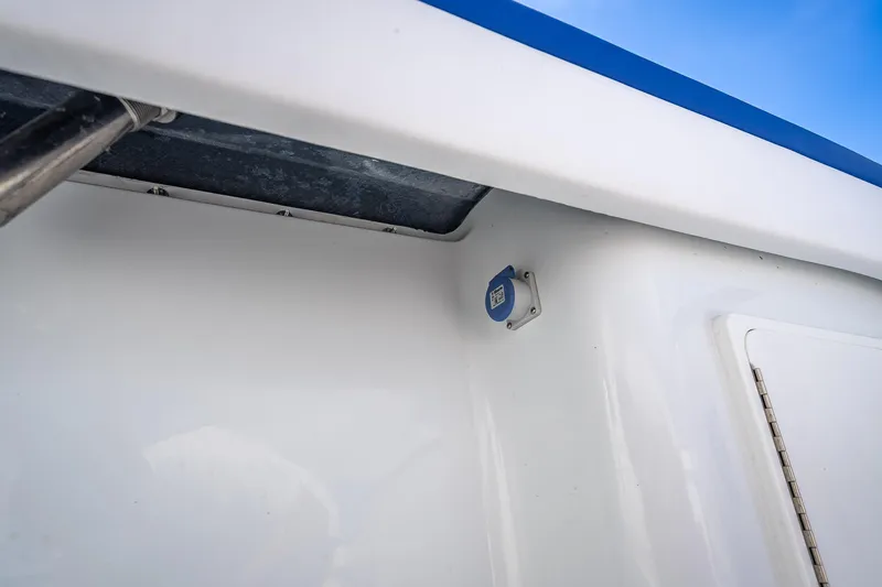 Slide: The Image of 2023 Yellowfin 39 Offshore boat detail with blue trim and mounted device. - 60