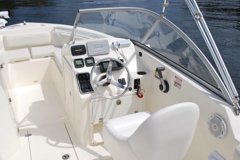 Slide: The Image of 2015 Cobia 220 Dual Console boat cockpit with steering wheel and Garmin navigation system. - 10