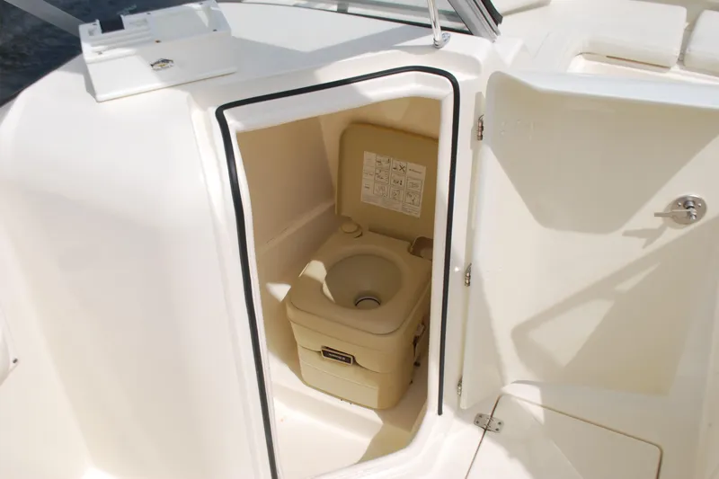 Slide: The Image of Portable toilet inside 2015 Cobia 220 Dual Console boat compartment. - 13