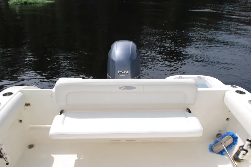 Slide: The Image of 2015 Cobia 220 Dual Console boat with Yamaha 150 engine on calm water. - 14