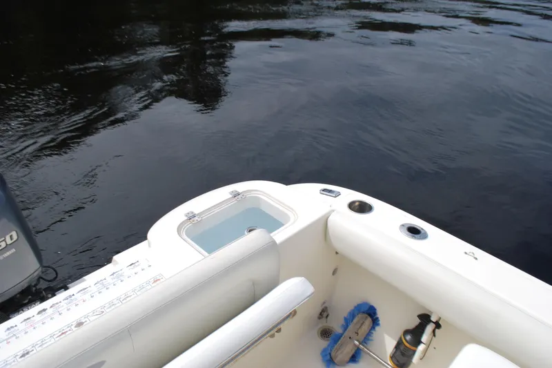 Slide: The Image of 2015 Cobia 220 Dual Console boat interior with water view and cleaning supplies. - 16