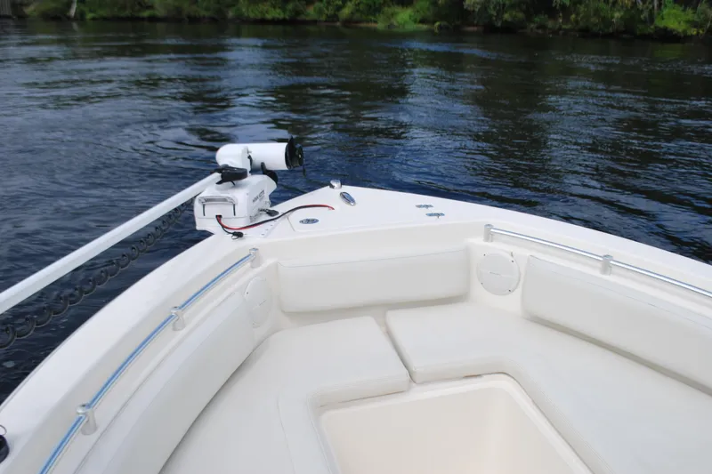 Slide: The Image of 2015 Cobia 220 Dual Console boat on calm water, featuring spacious seating and modern design. - 5