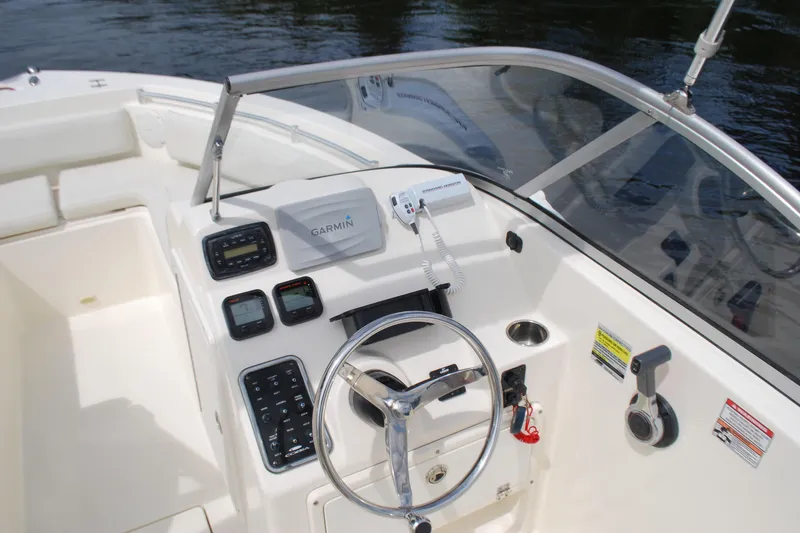 Slide: The Image of 2015 Cobia 220 Dual Console boat dashboard with Garmin navigation system and steering wheel. - 8