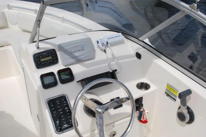 Slide: The Image of 2015 Cobia 220 Dual Console boat dashboard with Garmin navigation system and controls. - 9